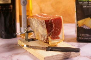 Block of cured meat on a wooden board with a knife,. Luxury Gift